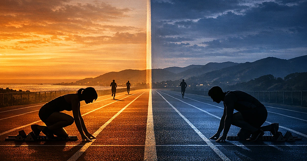 Silhouetted athletes in starting blocks on a divided running track under contrasting lighting at dusk