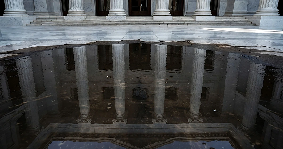Clean government building interior reflected as distorted and dark in murky water below, showing perception gap